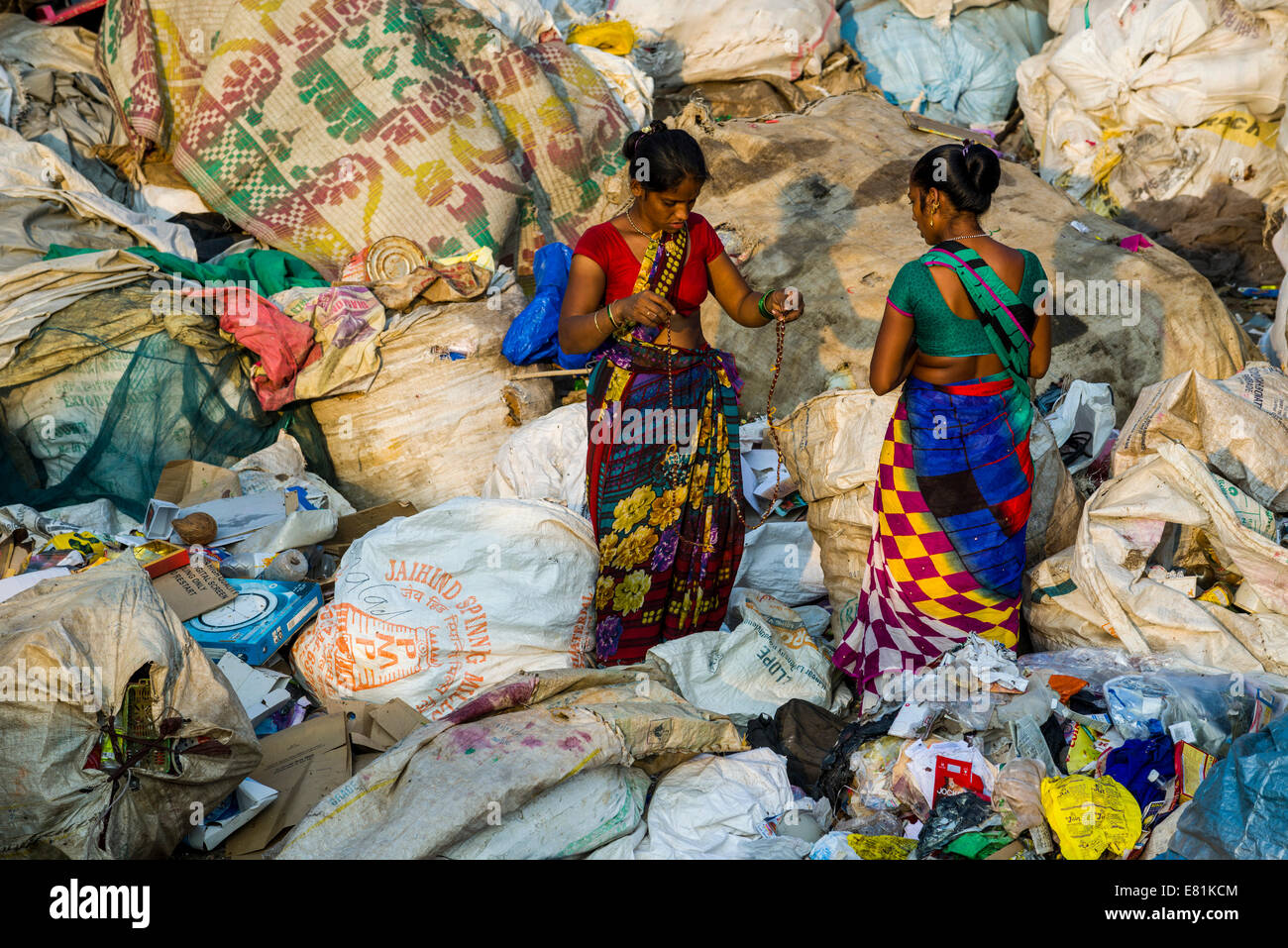 Zwei Frauen in bunten Saris sind aussortieren Müll zum recycling, im Dharavi Slum, Mumbai, Maharashtra, Indien Stockfoto