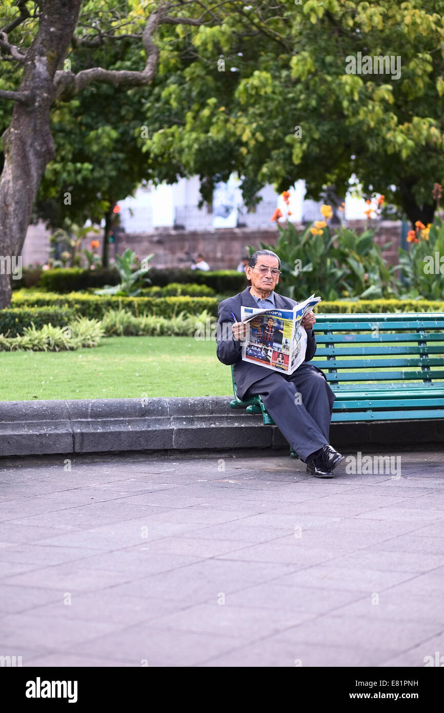 Älterer Mann liest Zeitung La Hora auf einer Bank am Plaza Grande (Hauptplatz in Quito, Ecuador Stockfoto