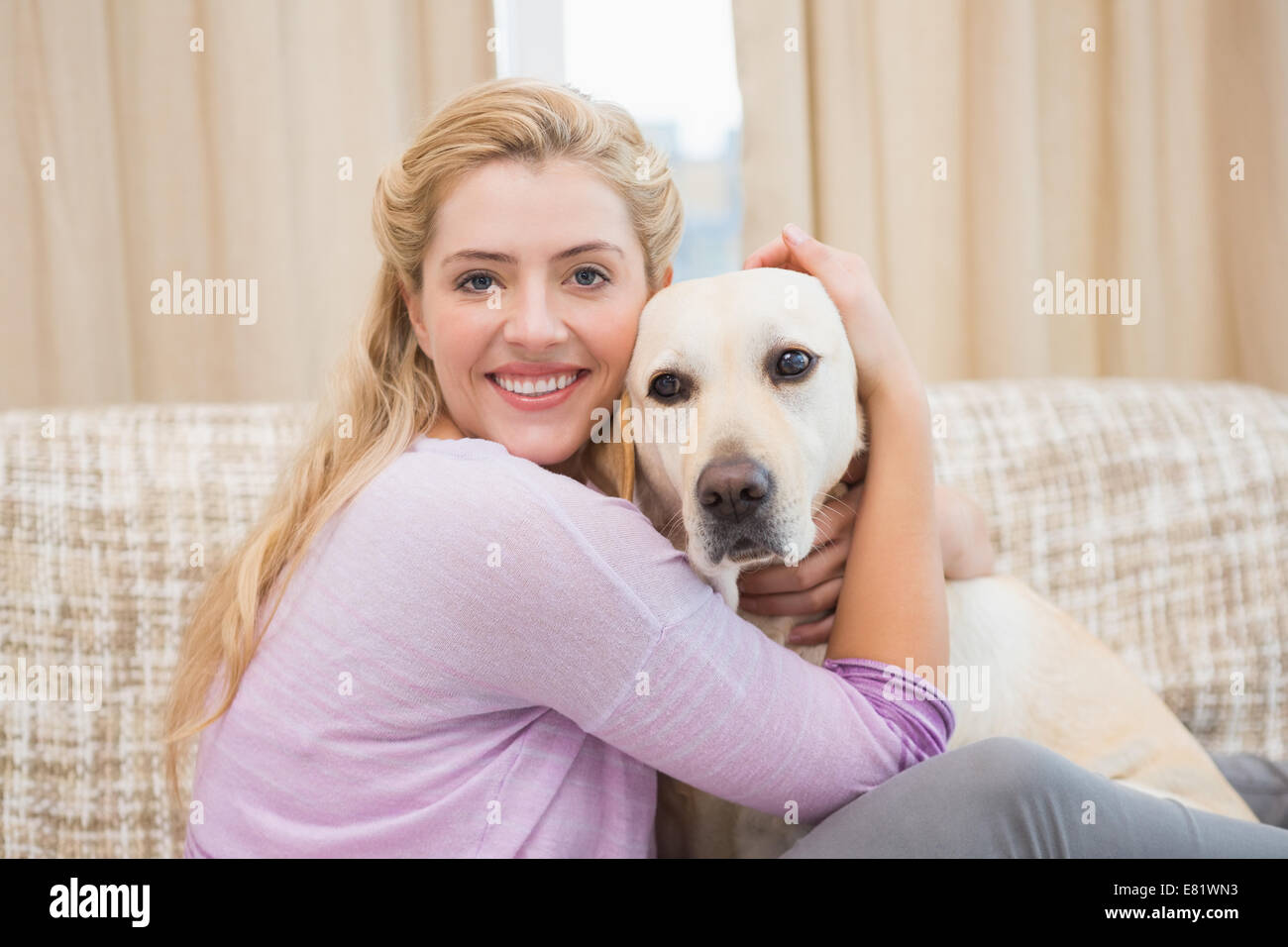 Schöne Blondine mit Hund auf couch Stockfoto