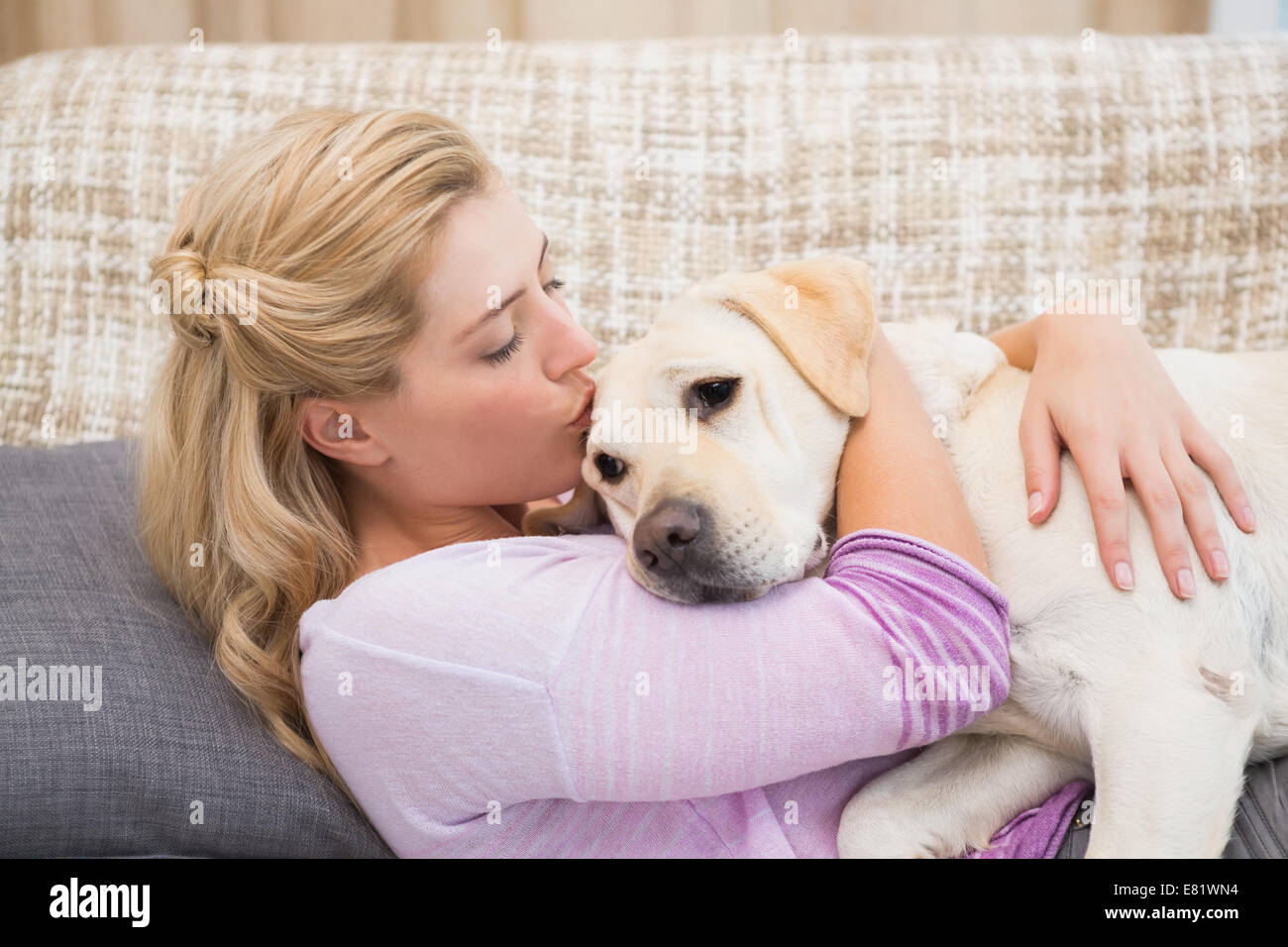 Schöne Blondine mit Hund auf couch Stockfoto