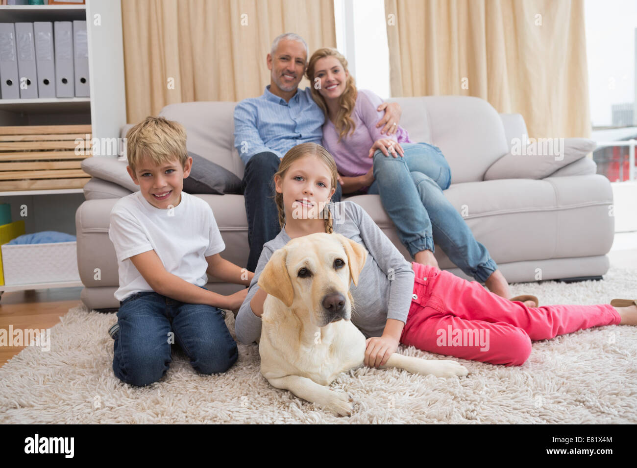 Eltern und ihre Kinder auf Sofa mit labrador Stockfoto