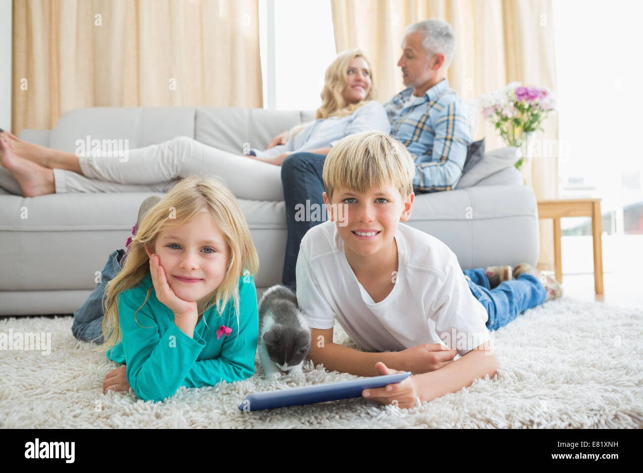 Geschwister mit Tablet-pc auf dem Boden Stockfoto