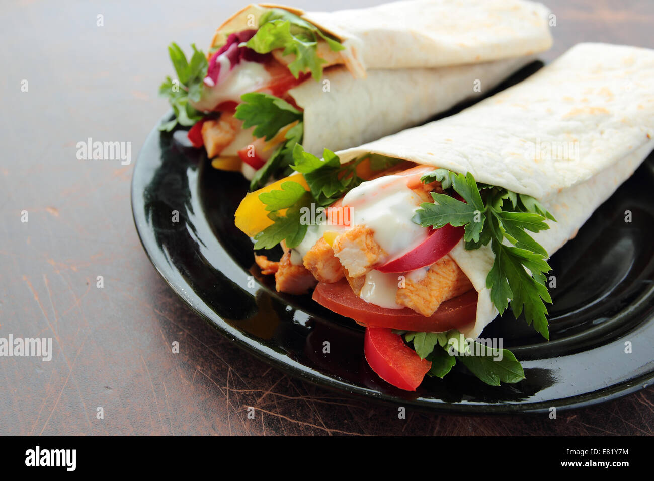 Platte mit leckere Tortilla wraps mit Huhn und frischem Gemüse Stockfoto