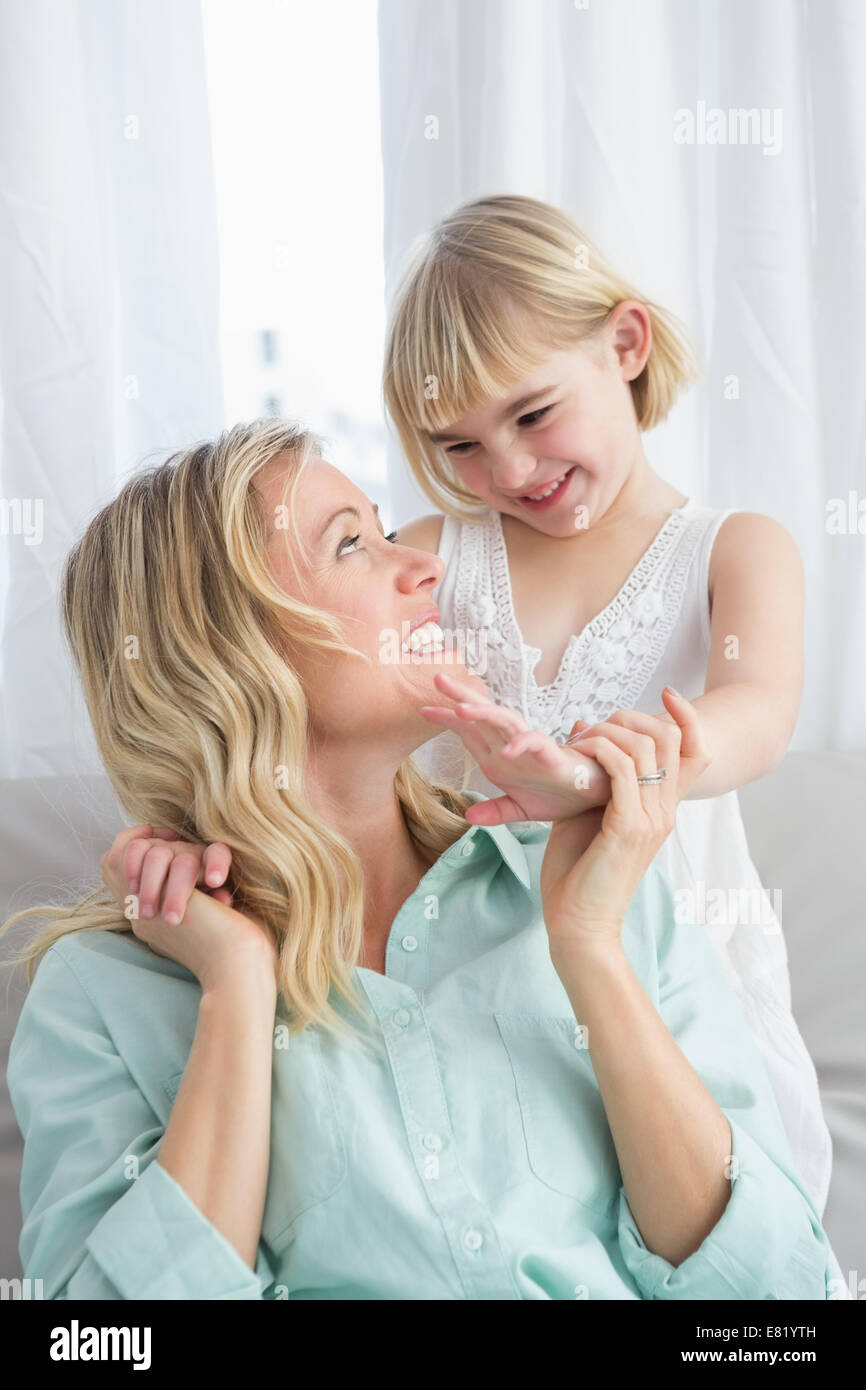 Porträt einer Mutter und Tochter hinter ihr auf der couch Stockfoto