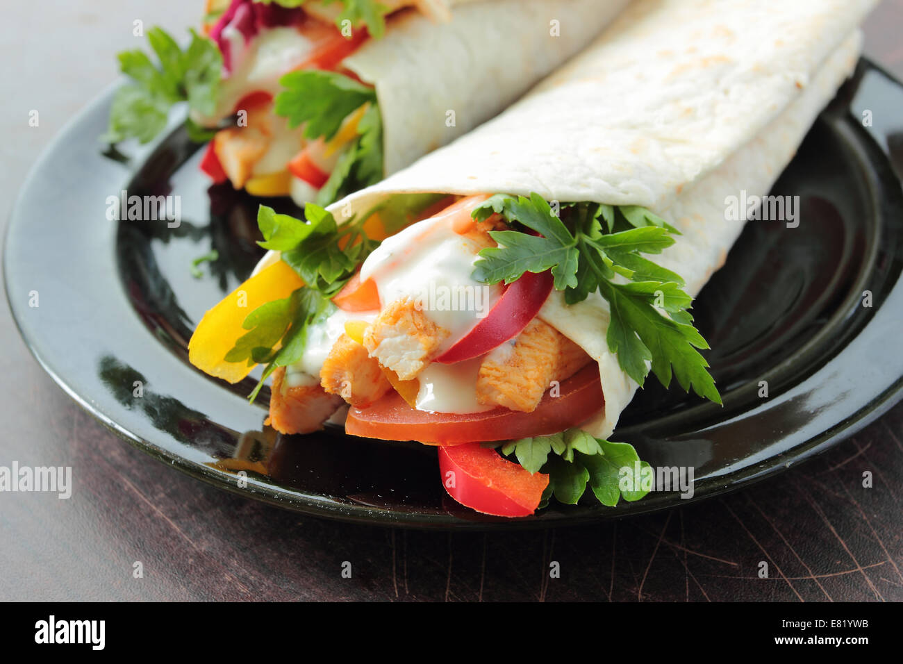 Tortilla-Wraps mit frischem Huhn und Gemüse auf einem Teller Stockfoto