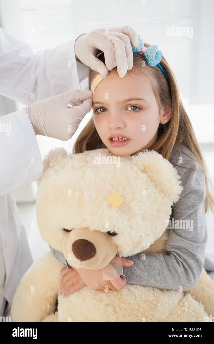 Mädchen bekommen ein Pflaster auf der Stirn Stockfoto