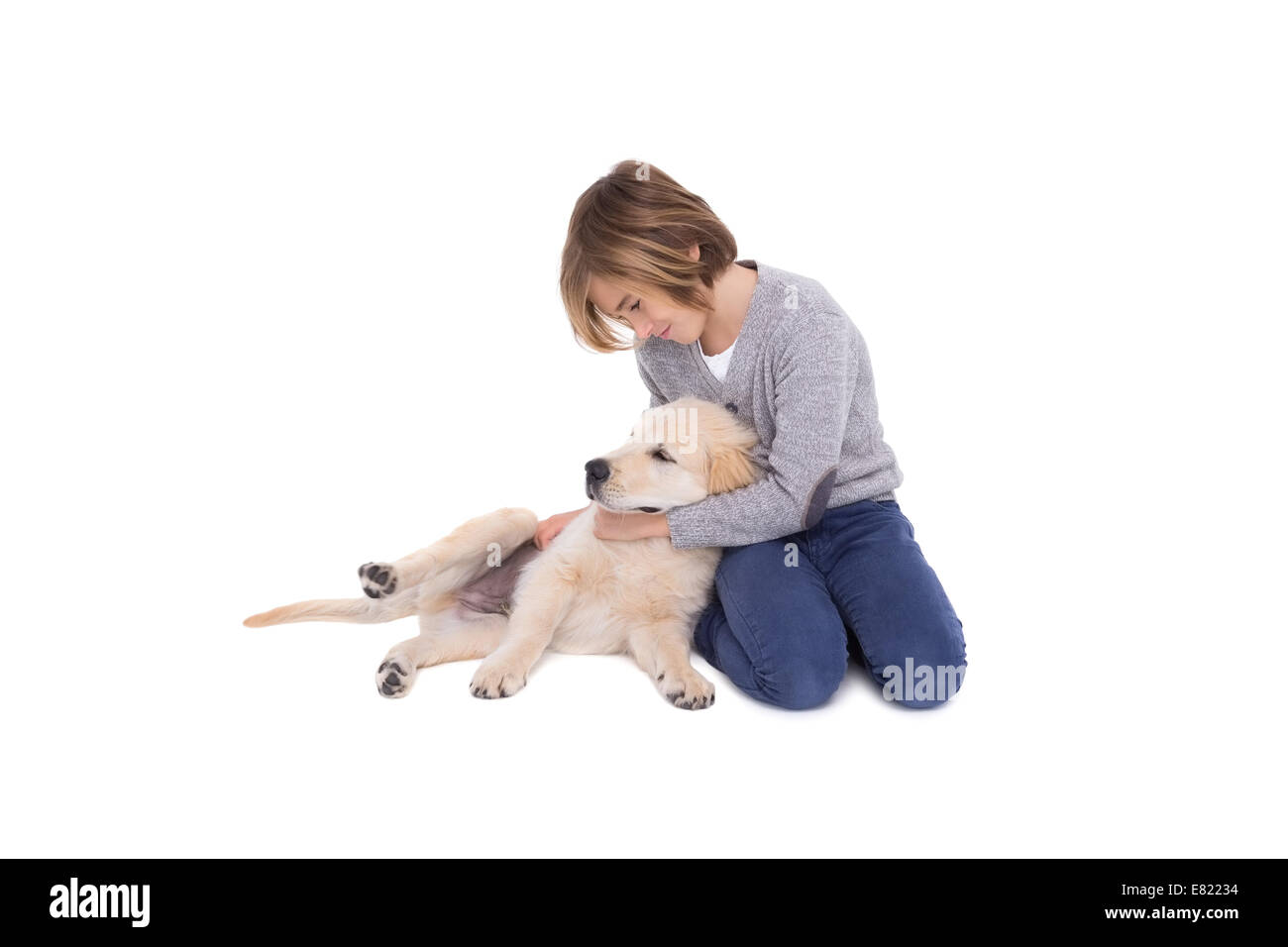 Niedliche kleine Junge kniend mit seinem Hund Stockfoto