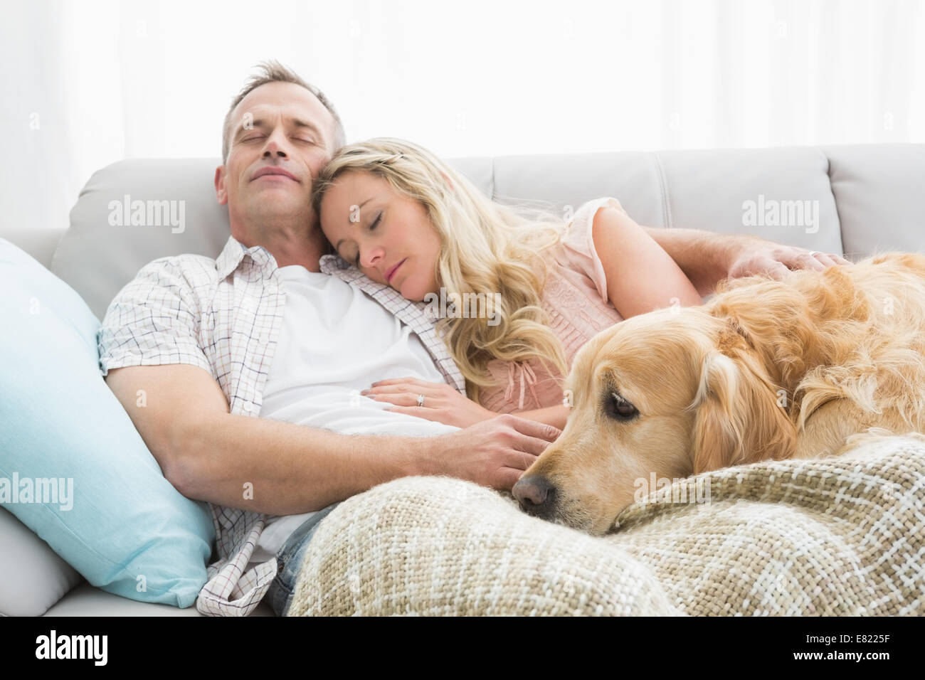 Liebespaar Nickerchen auf der Couch mit ihrem Hund Stockfoto