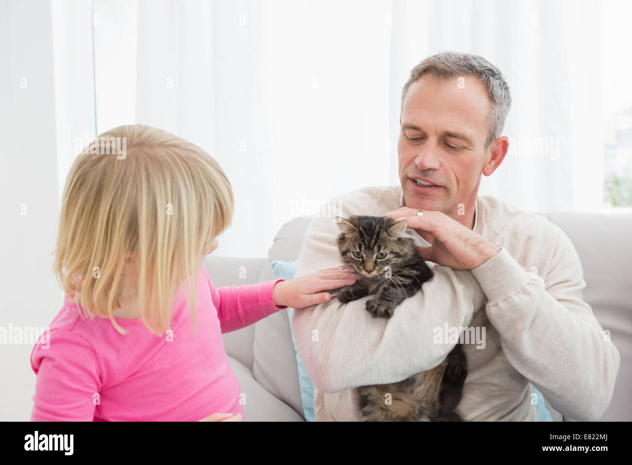 Glückliche Tochter und Vater Zusammensitzen mit Kätzchen Stockfoto