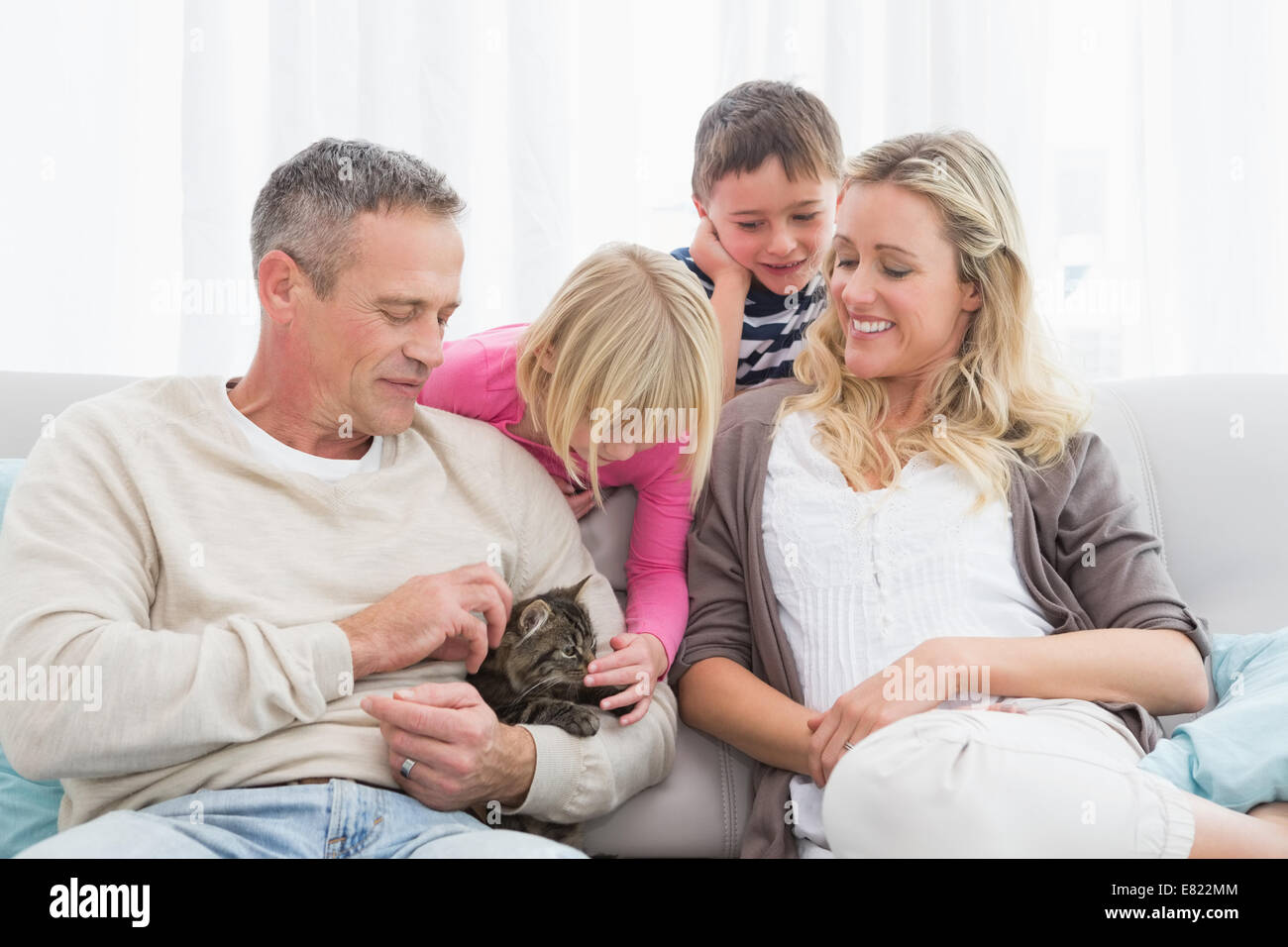 Glückliche Familie Zusammensitzen mit Kätzchen Stockfoto