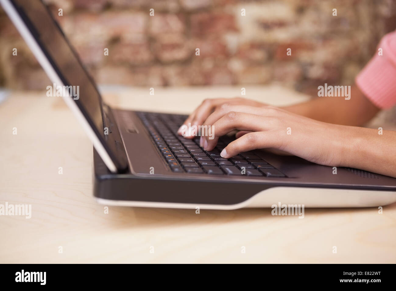 Mädchen, die Eingabe auf einem Laptop sitzt an ihrem Schreibtisch Stockfoto