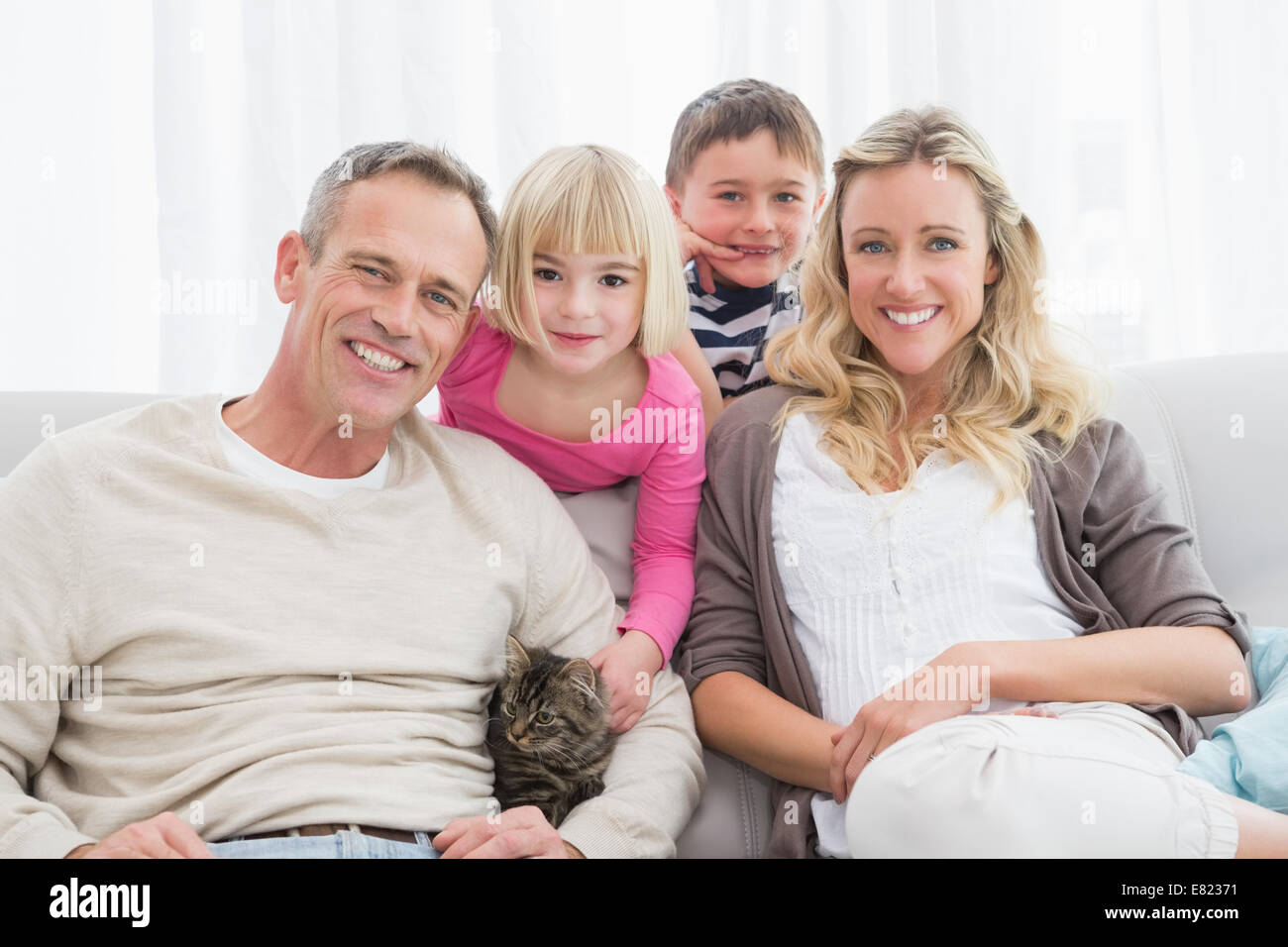 Glückliche Familie Zusammensitzen mit Kätzchen Stockfoto