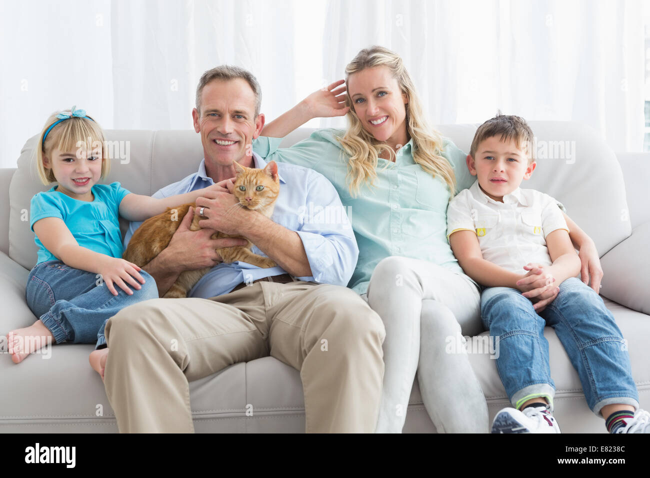 Nette Familie Entspannung zusammen auf der Couch mit ihrer Katze Stockfoto