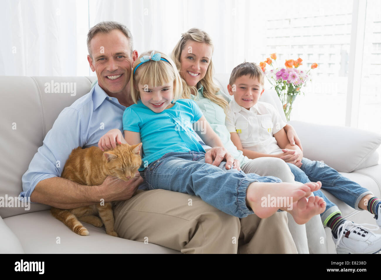 Nette Familie Entspannung zusammen auf der Couch mit ihrer Katze Stockfoto
