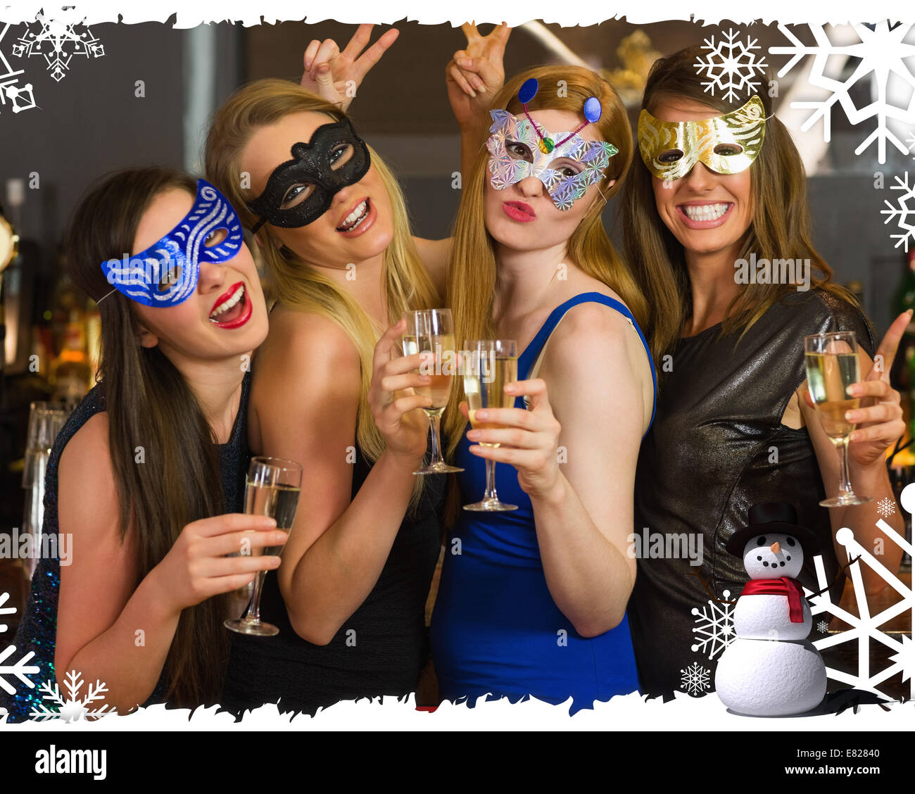 Attraktive Frauen tragen Masken mit Champagner Stockfoto