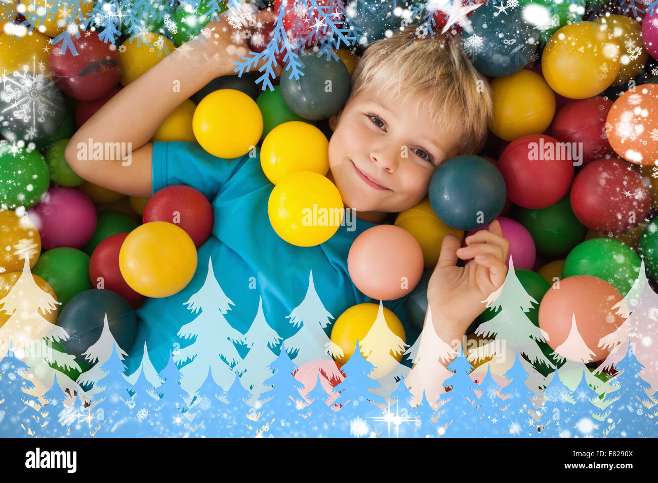 Zusammengesetztes Bild fröhlicher Junge spielt im Bällebad Stockfoto