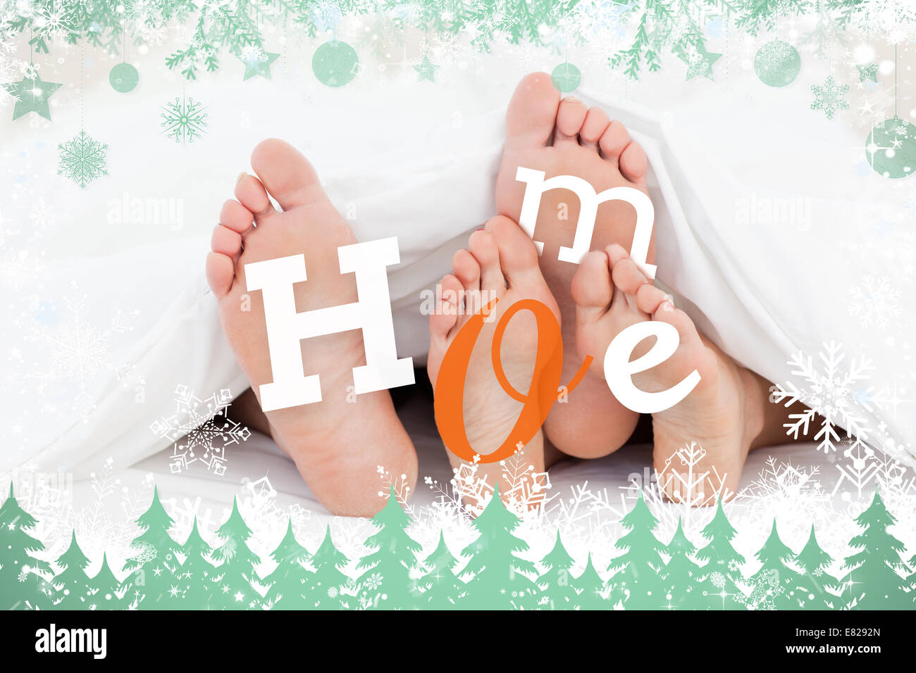 Zusammengesetztes Bild paar Füße unter der Bettdecke mit nach Hause text Stockfoto