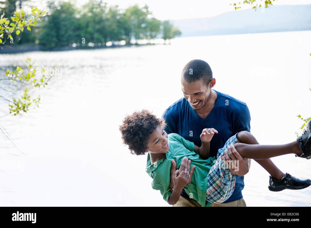 Vater spielt mit seinem Sohn trug ihn in seine Arme. Stockfoto