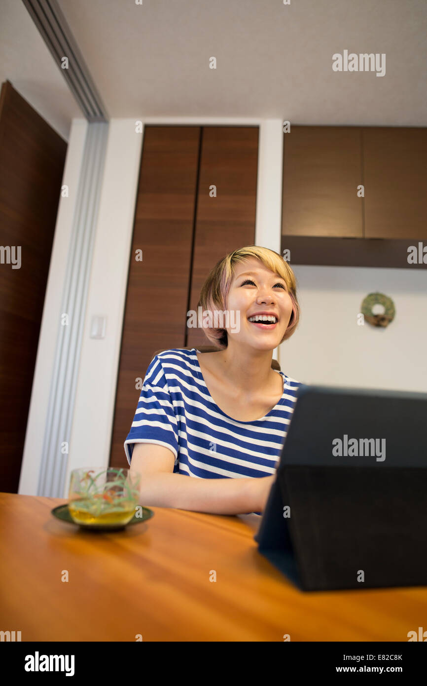 Eine Frau sitzt an einem Tisch mit einem Laptopcomputer. Stockfoto