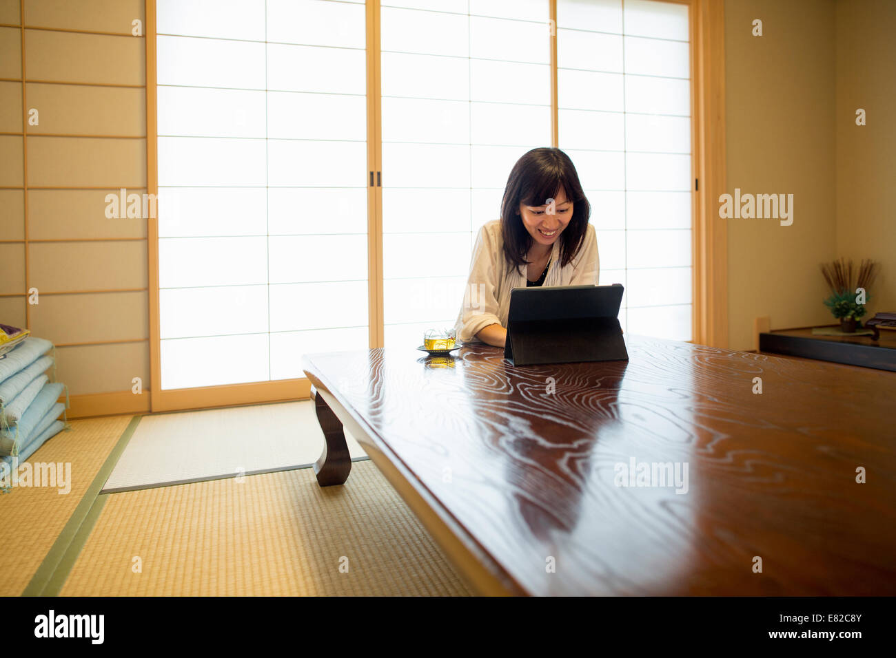 Eine Frau sitzt an einem Tisch mit einem Laptopcomputer. Stockfoto