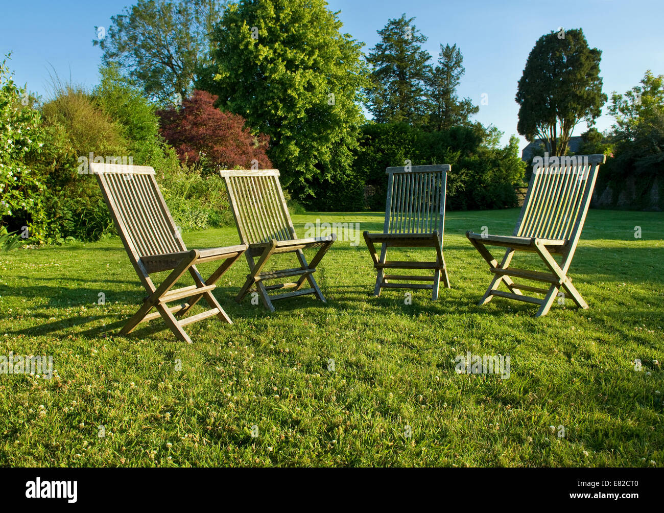 Gartenstühle platziert auf einer Wiese in Gloucestershire im Sommer gruppierten. Stockfoto