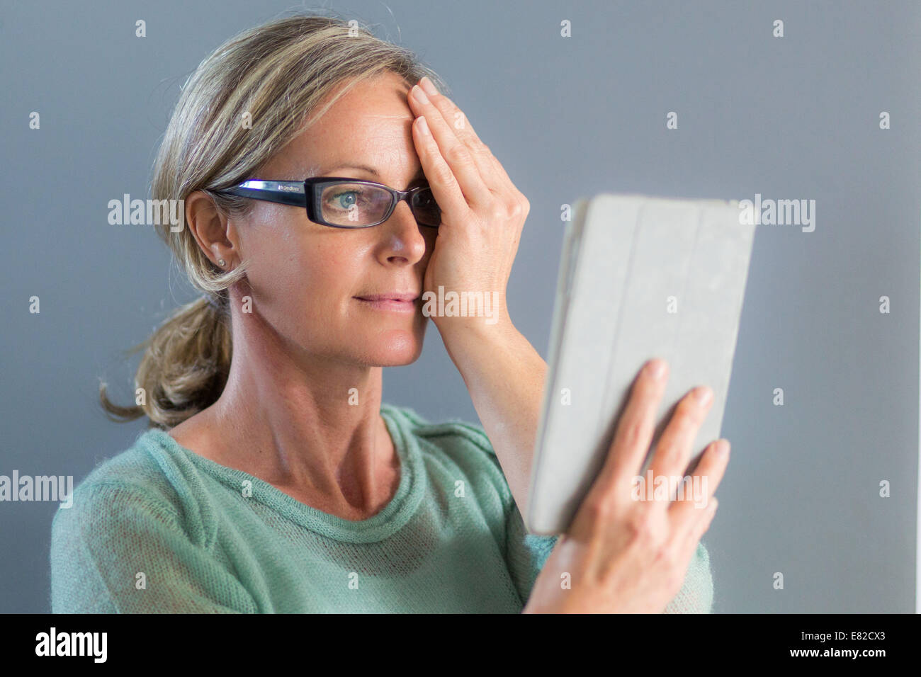 Ältere Frau betrachten ein Amsler-Gitters, Makula-Degeneration zu erkennen. Stockfoto