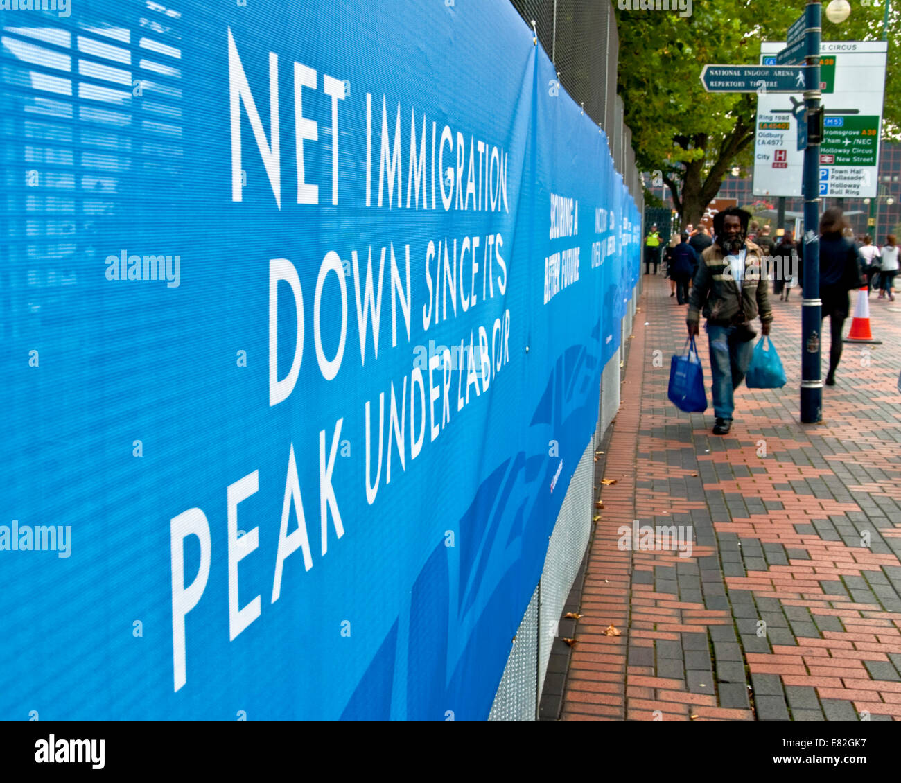 Birmingham, UK 29/09/2014. Ein Mann der Karibik Abfahrt Spaziergänge Vergangenheit eine konservative Slogan über Beschränkung der Einwanderung auf dem Parteitag der Konservativen Partei 2014, Birmingham (C) Paul Swinney/Alamy leben Nachrichten Stockfoto