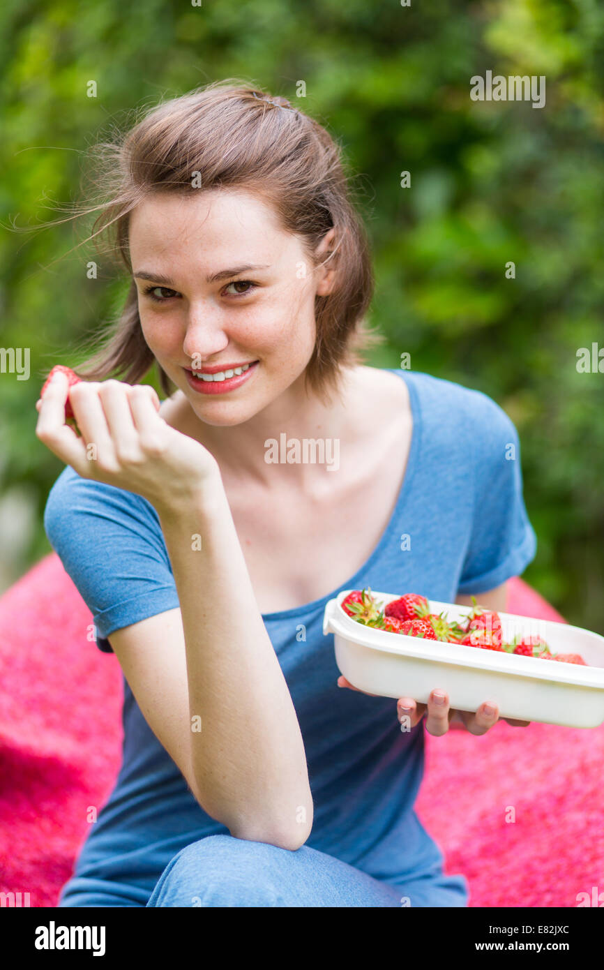 Junge Frau Erdbeeren essen. Stockfoto