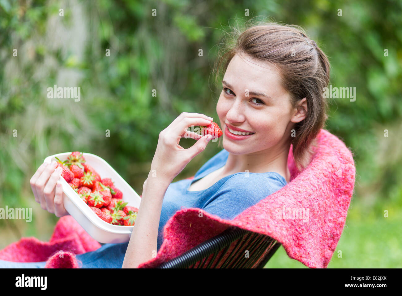 Junge Frau Erdbeeren essen. Stockfoto
