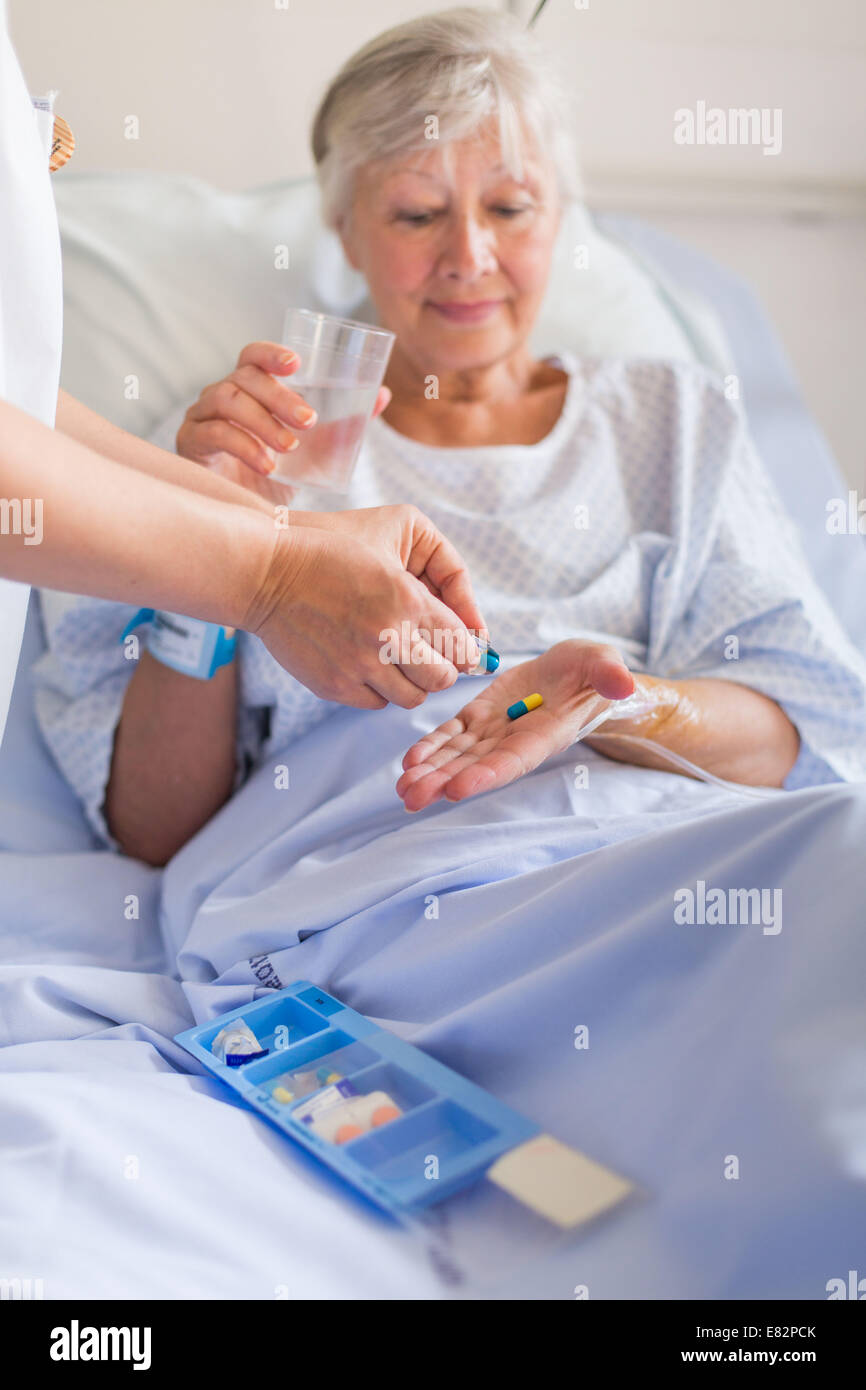 Krankenschwester, die ein Patient im Krankenhaus Medikamente geben. Stockfoto