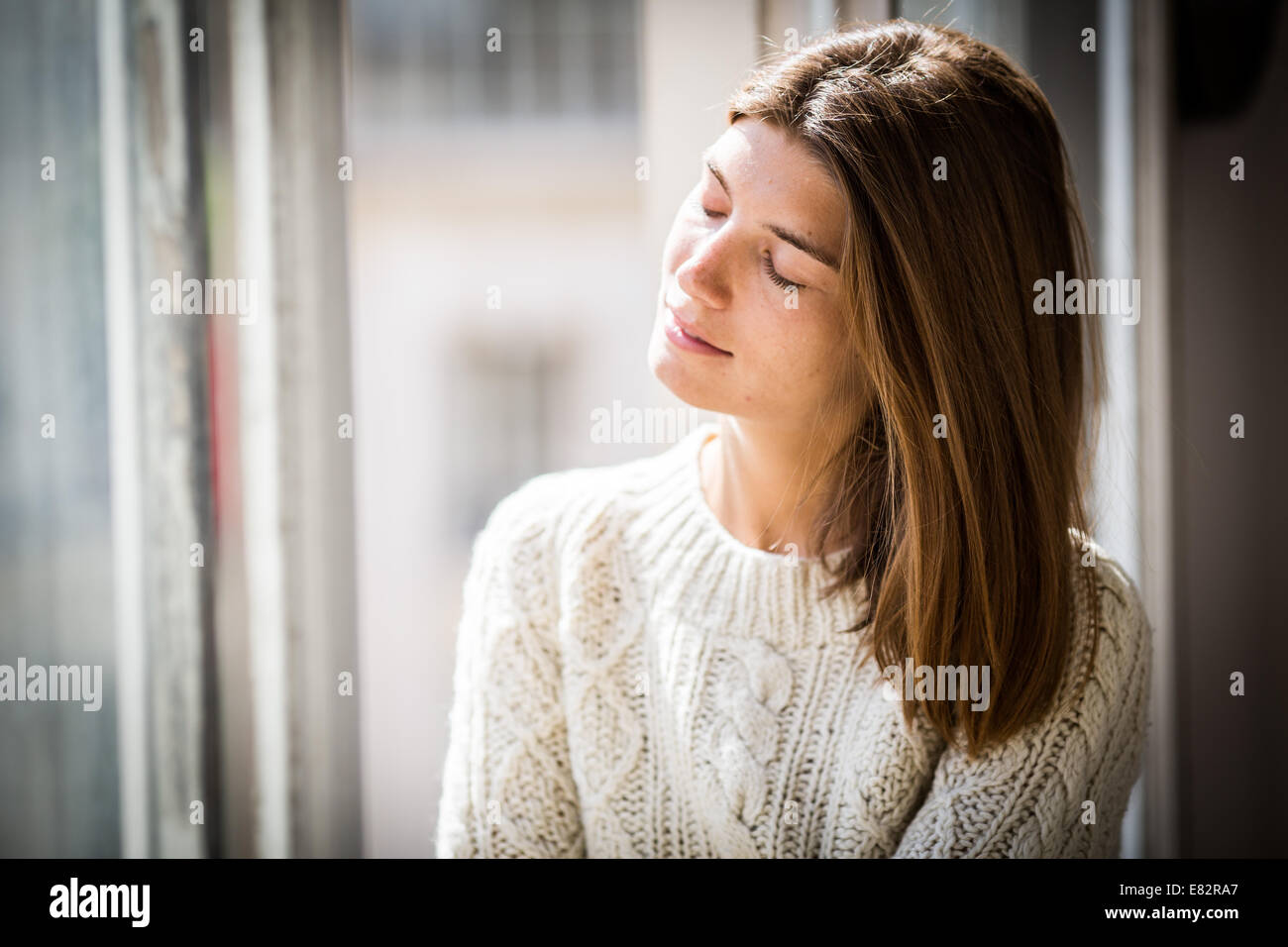 Frau, die durch das Fenster. Stockfoto