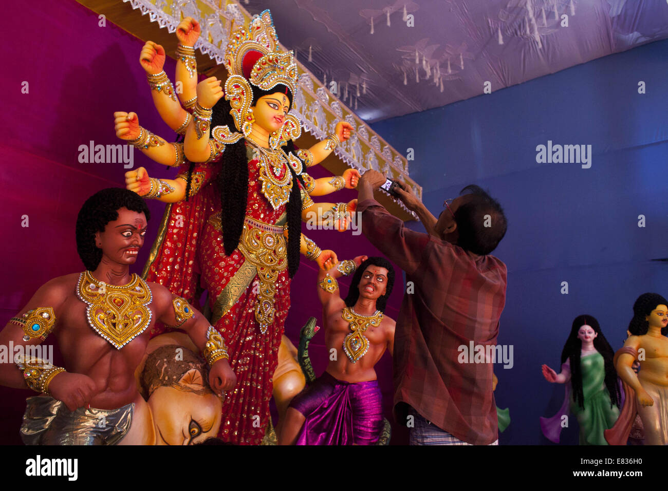 Dhaka, Bangladesch. 29. Sep, 2014. Ein Durga Idol Schöpfer unter Bild der Göttin Durga, die er geschaffen hatte. Bereit für die Durga Puja.Durga Göttin Durga ist unbesiegbar Muttergöttin, einem Löwen in die Schlacht reiten. Von den Göttern geschaffen, wenn das Böse das Universum bedroht, sie ist "˜Shakti" die göttliche Kraft gegen stehen, zu absorbieren und dunkle Mächte zu kämpfen. In Anbetung, bekannt als Puja feiern Hindus die Niederlage des Bösen von Durga.Hindu Gott und Göttinnen wie das größte Festival des hinduistischen Gläubigen Durga Puja genannt. Bildnachweis: Zakir Hossain Chowdhury/ZUMA Draht/Alamy Live-Nachrichten Stockfoto