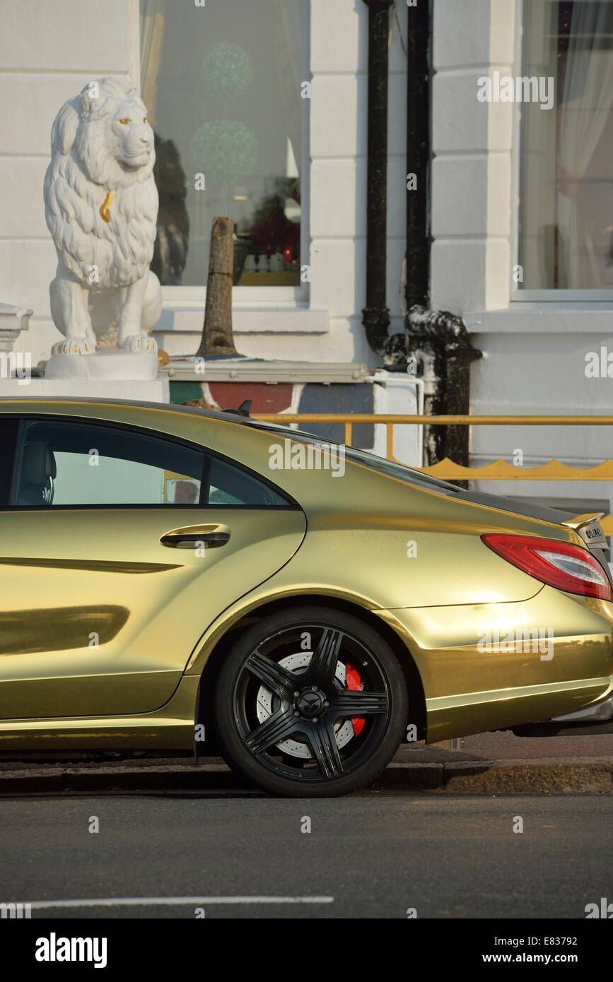 Gold lackierte Mercedes Benz Sport-Limousine auf Eastbourne Strandpromenade geparkt Stockfoto