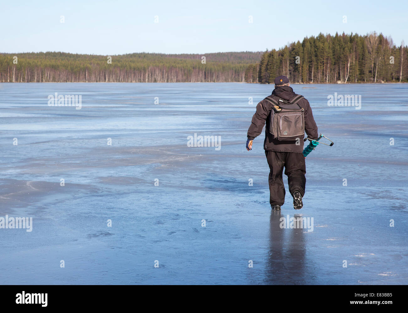 Isolierter älterer Mann, der in Spring, Finnland, Eisfischen geht Stockfoto