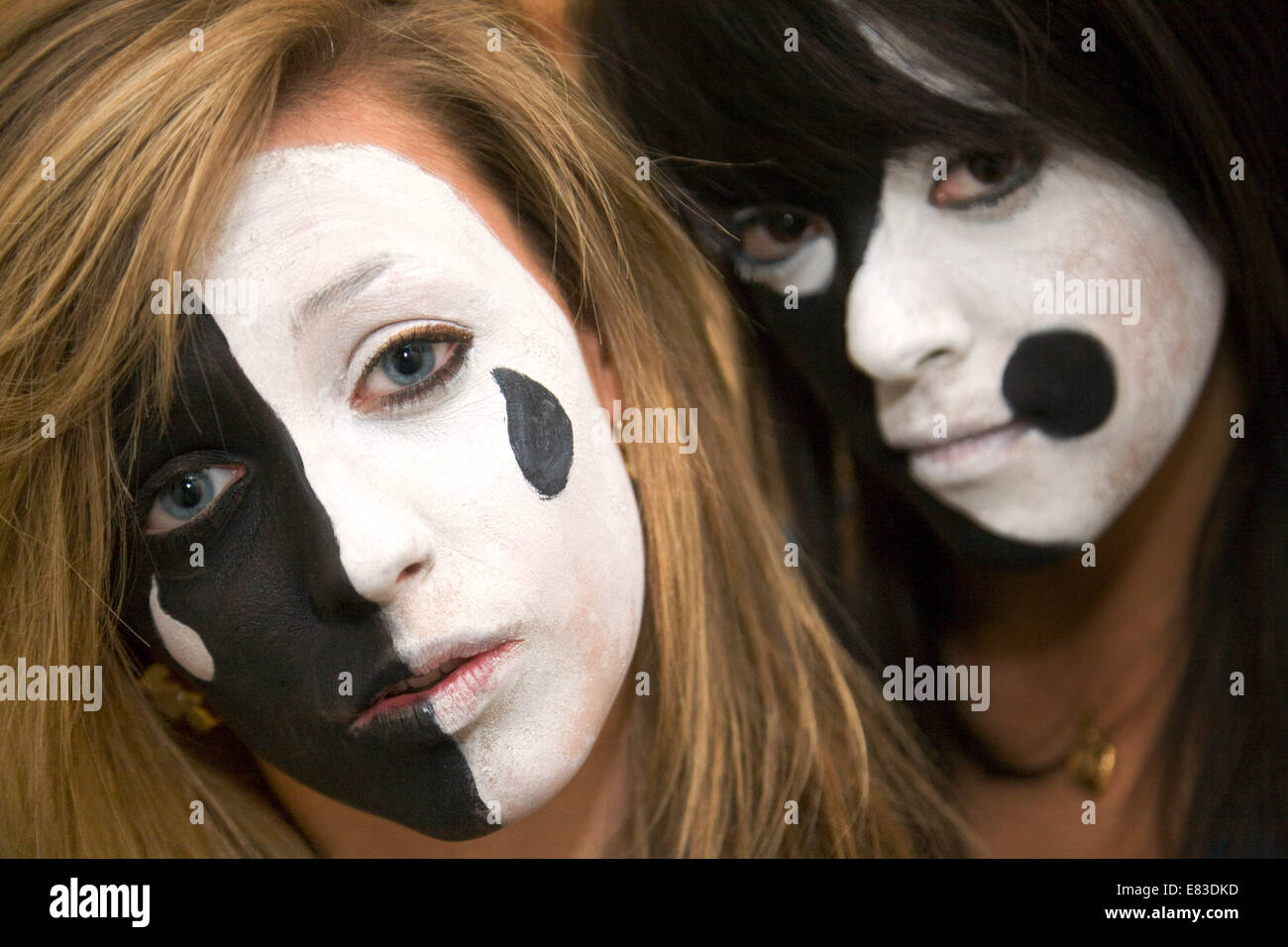 Zwei kaukasischen Teenager-Alter im Alter von 15 Jahren, hatte ihre Gesichter gemalt in dramatischen Farben schwarz und weiß, UK Stockfoto