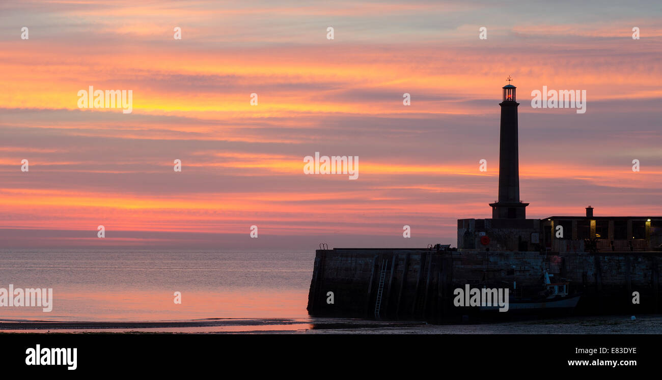 Sonnenuntergang in Margate, Kent, England, zeigt Teil He Hafenmauer und den Leuchtturm Stockfoto