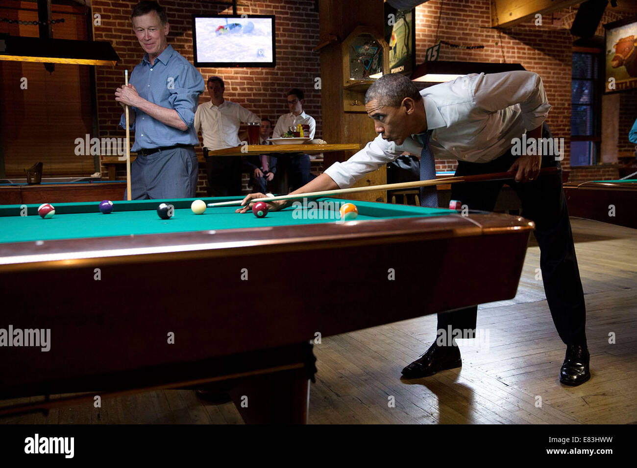 Präsident Barack Obama pfeift entlang der Musik wie er Pool mit Gouverneur John Hickenlooper, D -Colorado in Denver schießt. Stockfoto