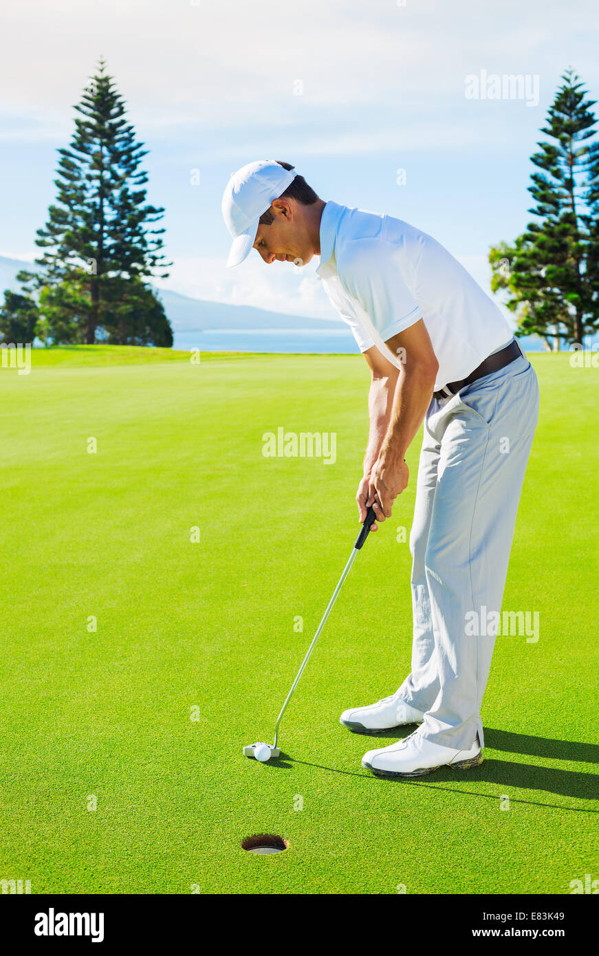Golfer auf Putting-Green Golfball ins Loch zu schlagen Stockfoto