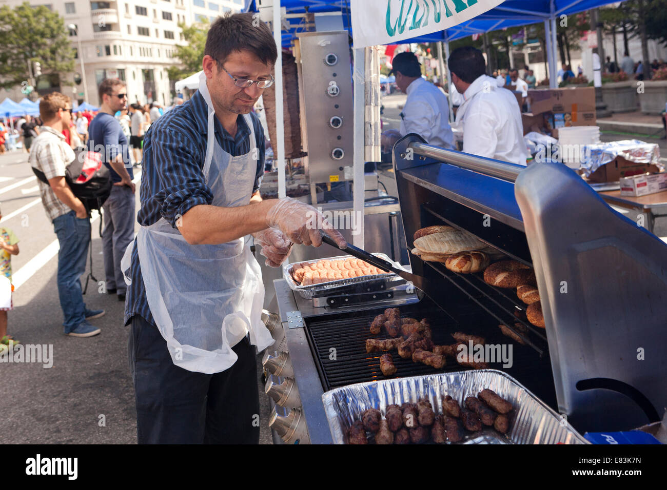 Mann Kochen türkische Ćevapčići auf Grill am Outdoor-Festival - USA Stockfoto