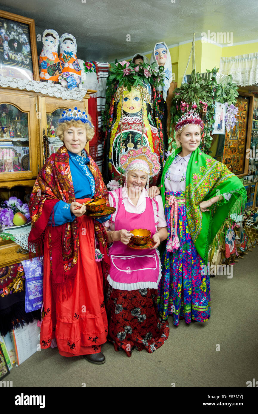 Russisches Alaska - Nikolaevsk AK Menschen tragen russische Tracht im Souvenirladen. Stockfoto