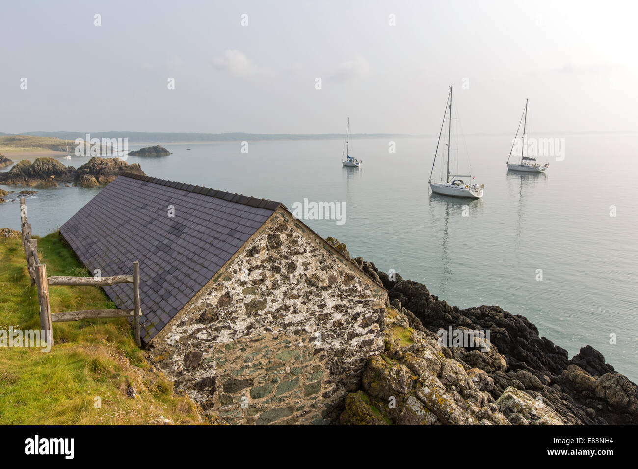 Segelboote vor Anker in der Morgendämmerung, Ynys Llanddwyn Island, Anglesey, North Wales, UK Stockfoto