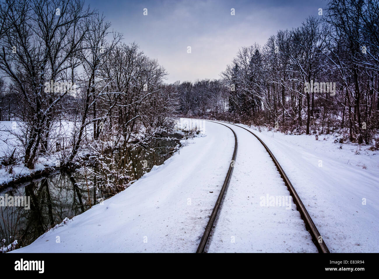 Schneebedeckten Eisenbahnschienen und Creek im ländlichen Carroll County, Maryland. Stockfoto