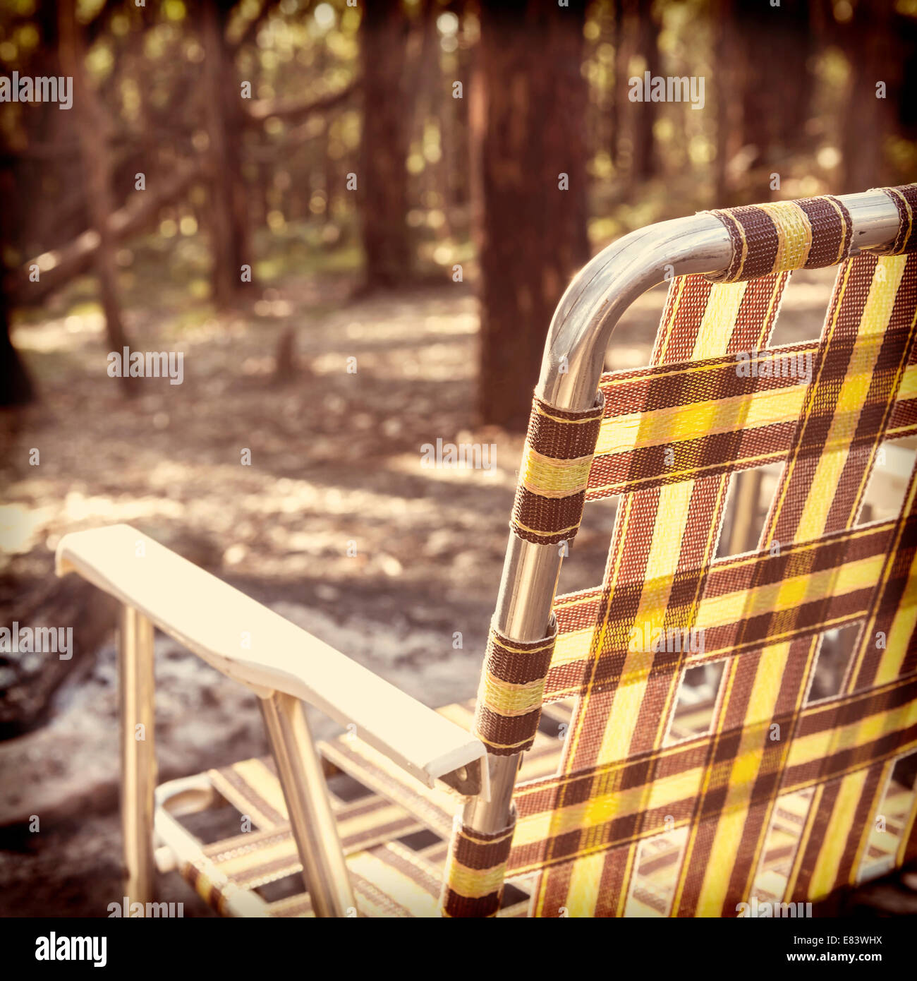 Retro-hochklappen Campingstuhl vor dem Feuer im Wald mit Instagram-Stil-filter Stockfoto