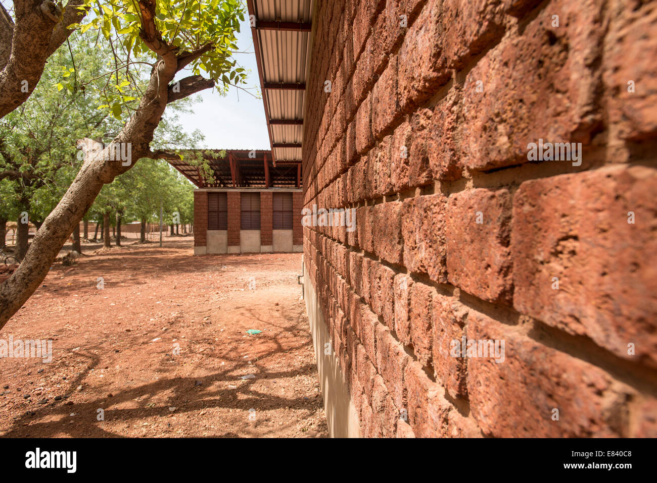 Bethel School, Gourcy Gourcy, Burkina Faso, Burkina. Architekt: Artikel 25, 2013. Detail der Lacterite Steinmauer mit Baum. Stockfoto