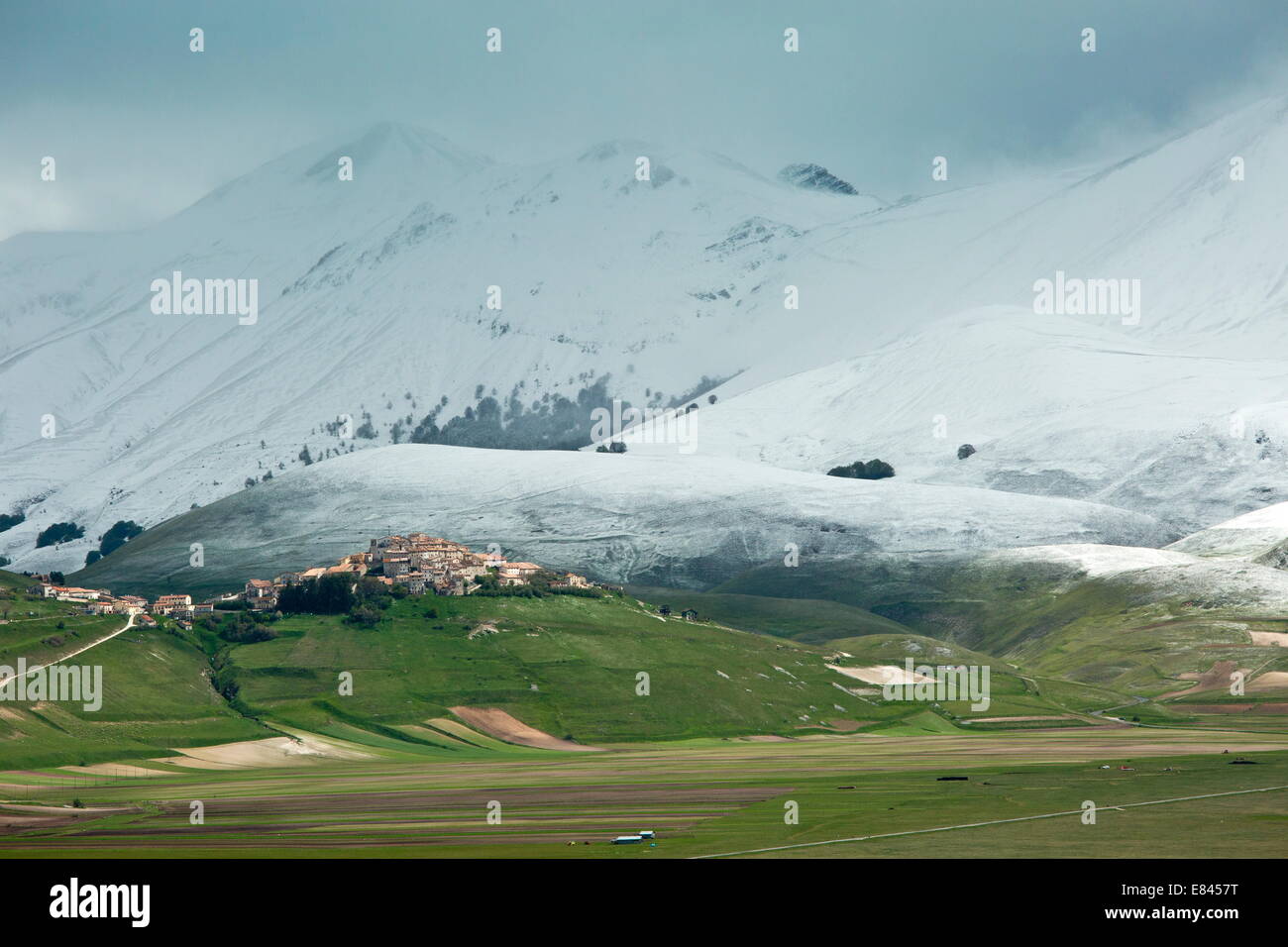 Castelluccio di Norcia und dem Piano Grande im späten Frühling mit schneebedeckten Bergen; Monti Sibillini Nationalpark, Italien. Stockfoto