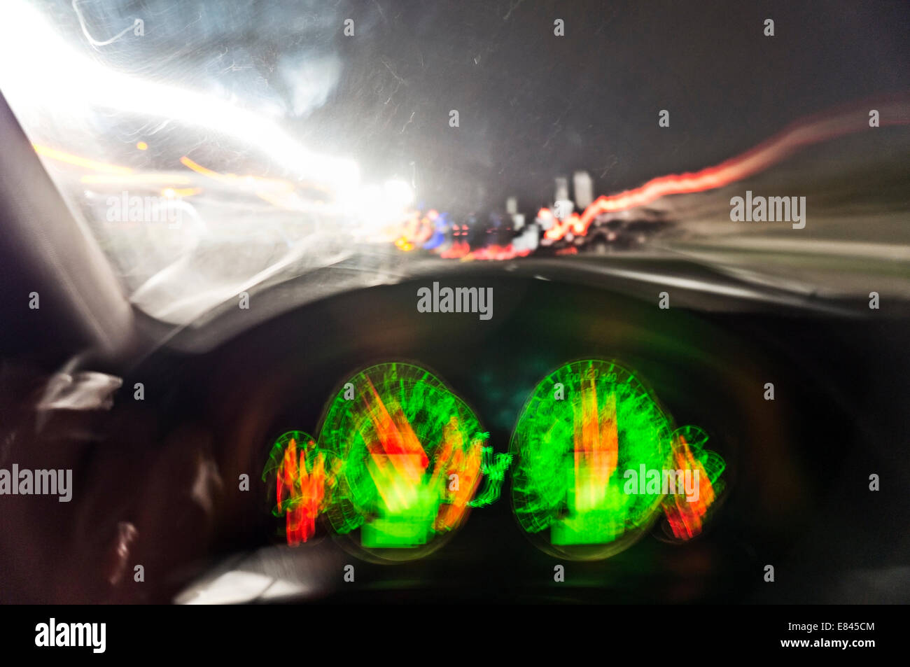 Armaturenbrett eines Fahrzeugs mit Gegenlicht durch die Windschutzscheibe und die starke Bewegung verwischen. Stockfoto