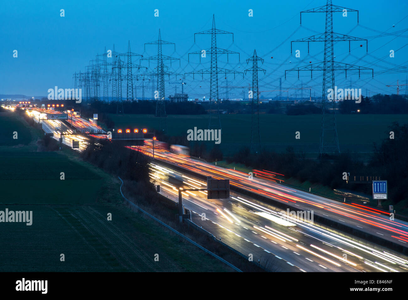 Autobahn A5 in der Nähe von Frankfurt am Main am Abend. Neben der Straße führt eine aktuelle Zeile. Stockfoto