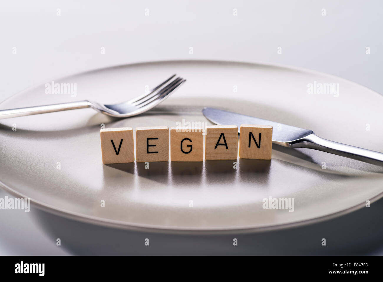 Teller mit Messer und Gabel und das Wort "Vegan" Stockfoto