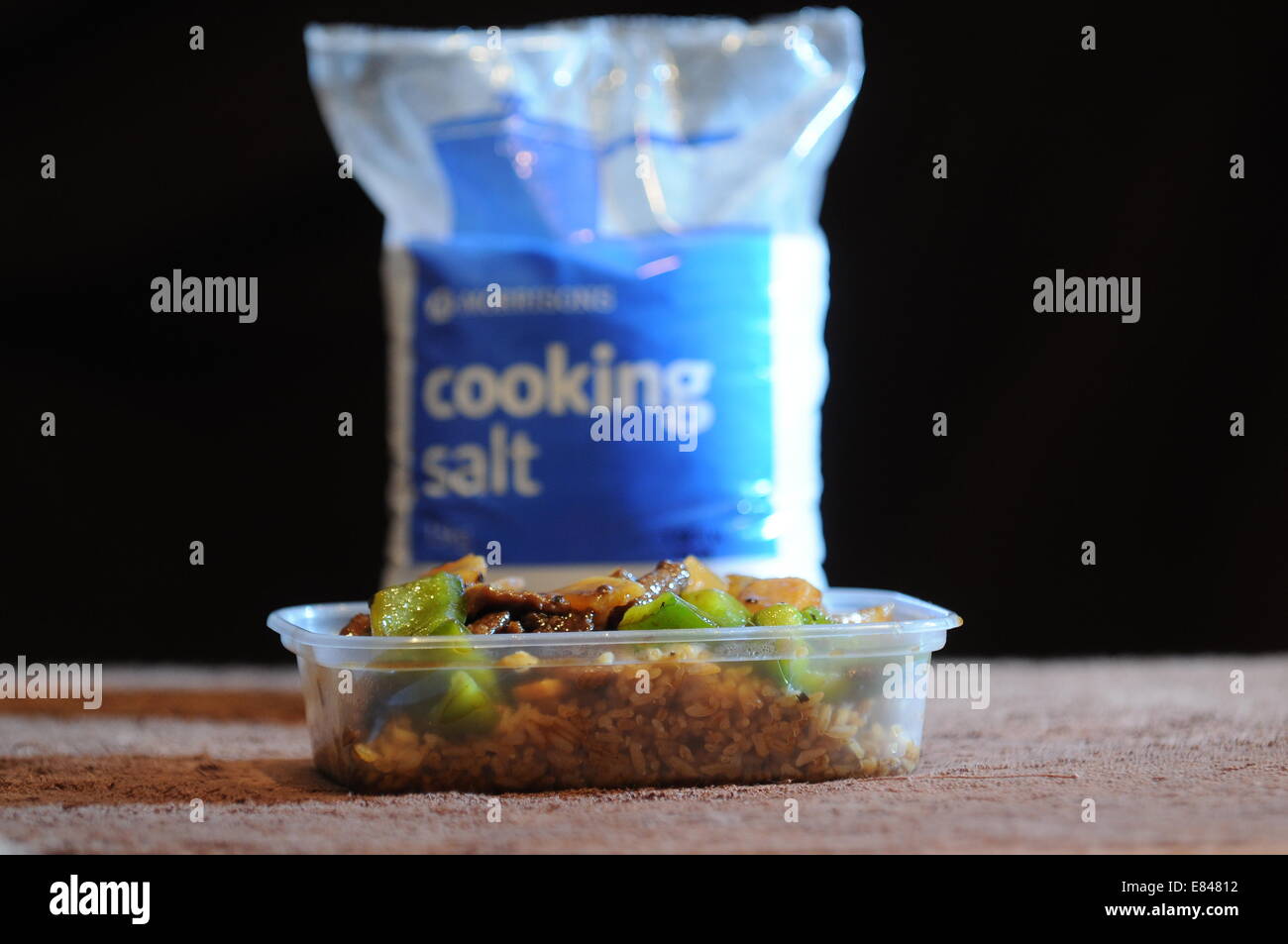 Speisen zum mitnehmen, mit einer Tasche von Kochsalz hinter. Hohe Niveaus des Salzes in Junk-Food verursachen Bluthochdruck und Herz-Kreislauferkrankungen. Stockfoto