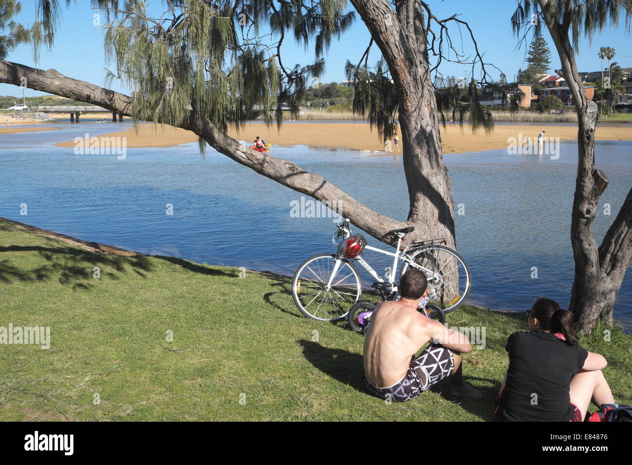 männliche Erwachsene Radfahrer und Freund machen Sie eine Pause am See Narrabeen, sydney Stockfoto